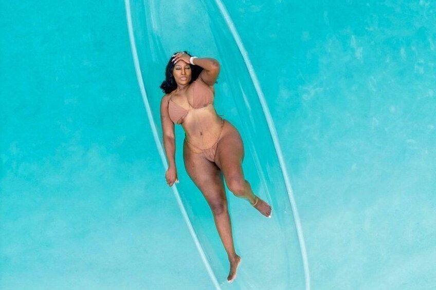A person in a bikini floating in a clear blue pool. 3
