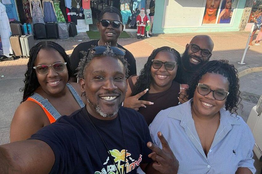 Un groupe de personnes prenant un selfie dans un endroit en plein air, avec la façade d’un magasin en arrière-plan. 2
