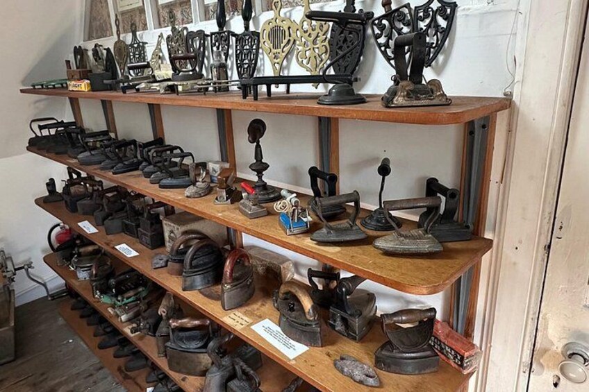 Shelves with various antique irons and ironing boards. 5