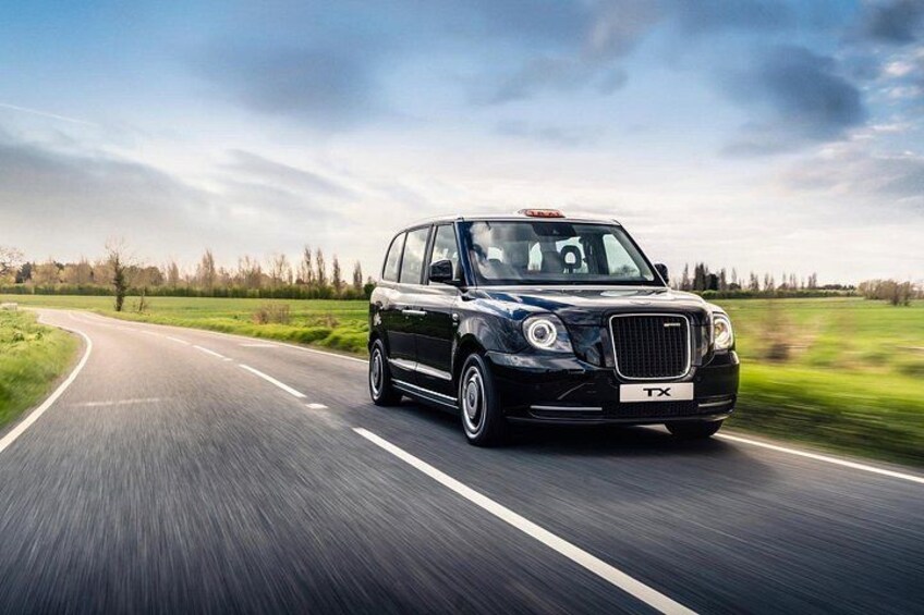 A black luxury car driving on a highway with a clear sky. 2