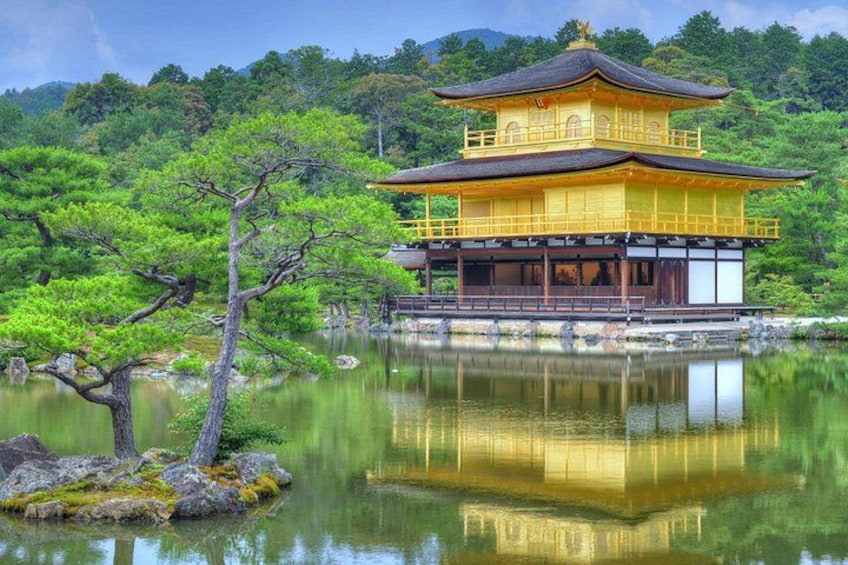 A traditional Japanese building with a golden facade, surrounded by a tranquil lake and lush greenery. 1