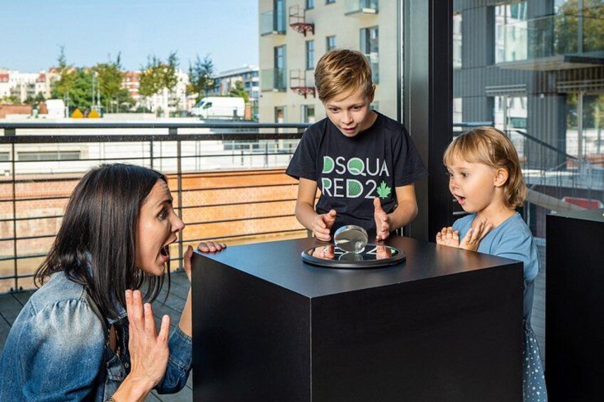 A person performing a magic trick with a coin at a table. 4