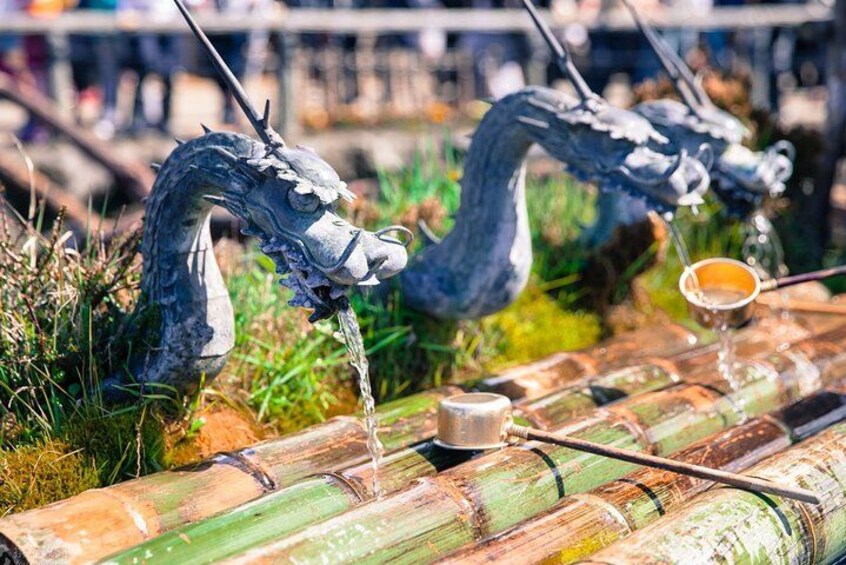 A dragon sculpture with a cup of tea on a bamboo mat. 2