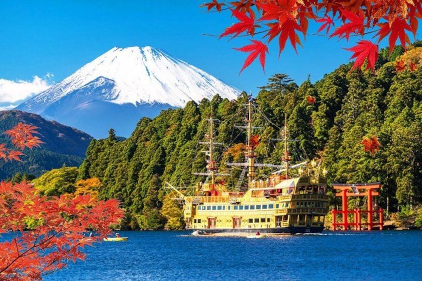 A cruise ship, a traditional Japanese torii gate, and Mount Fuji in the background. 2