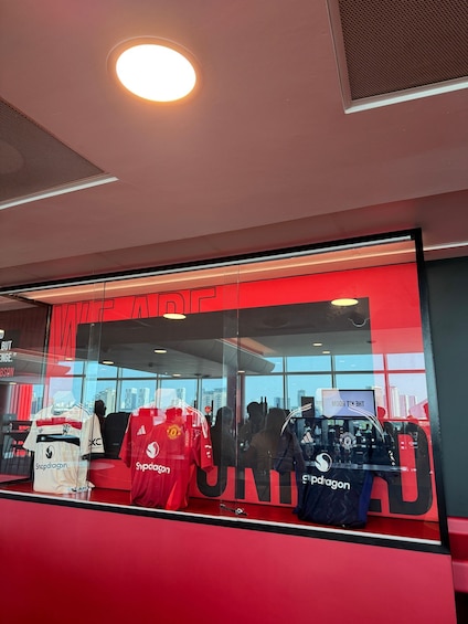 A sports store with a red and white color scheme, featuring Manchester United merchandise. 4