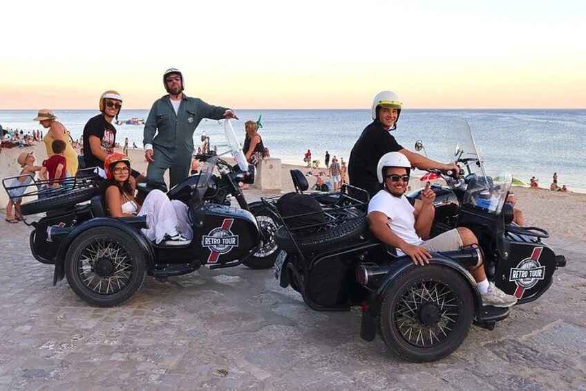 En strandscene med mennesker på veteranmotorcykler. 4