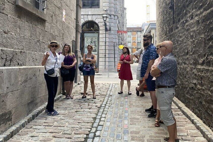 A group of people walking on a cobblestone street in a historic area. 2