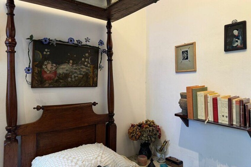 Una camera da letto con un letto a baldacchino, un quadro floreale, una libreria e un quadro incorniciato appeso al muro. 4