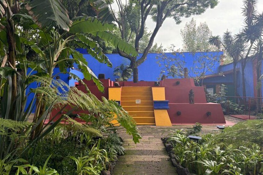 Un'area giochi colorata all'aperto con uno scivolo e strutture per arrampicarsi, immersa nel verde. 5