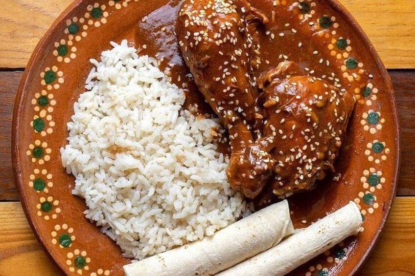 Un plato con arroz, un guiso de pollo y tortillas. 2