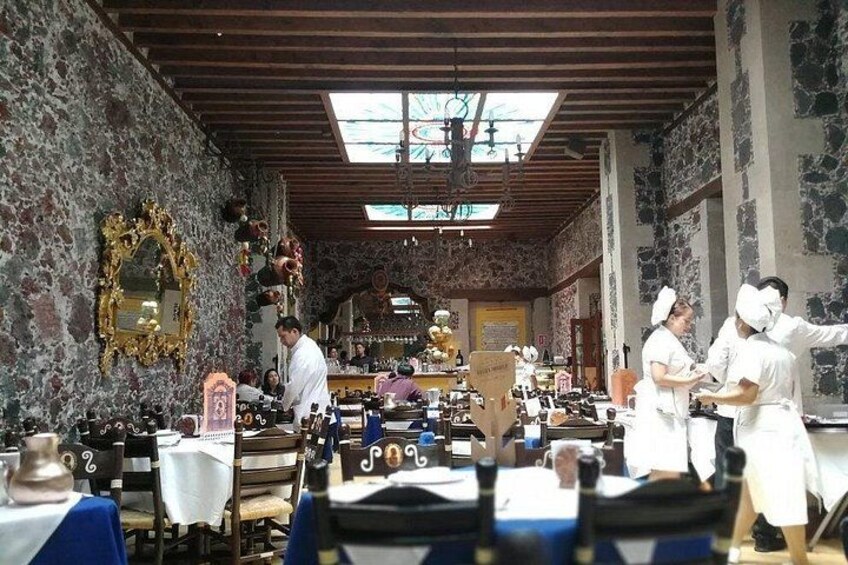Interior de restaurante con paredes de piedra, vigas de madera y un espejo grande. 5