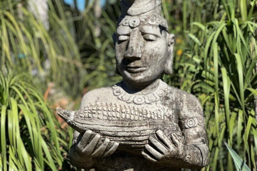 Eine Steinstatue einer Figur, die einen Fisch hält. 2