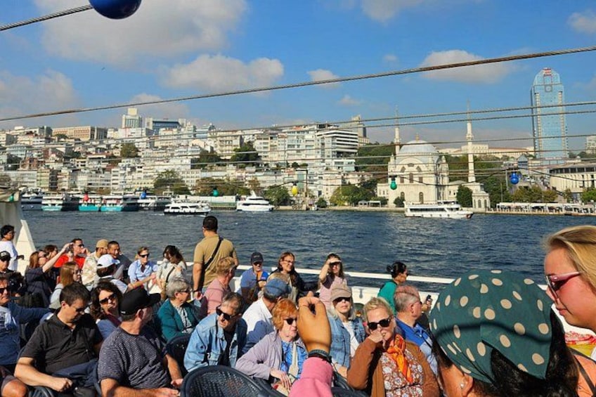 A crowded boat tour with a cityscape in the background. 4