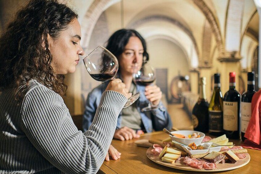 Two people tasting wine at a table with cheese and charcuterie. 4