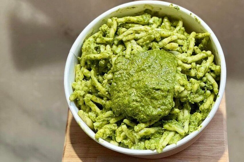 A bowl of pasta with pesto sauce. 2