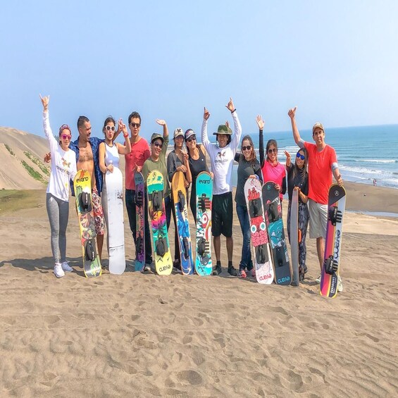 A group of people on a beach holding snowboards. 2