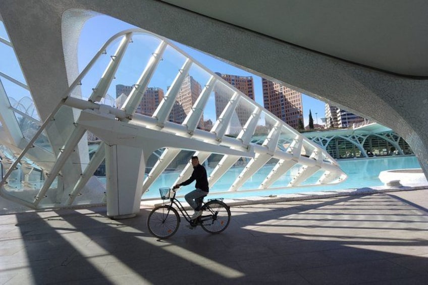 Une personne à vélo, circulant sous une grande structure blanche dotée d’un plancher transparent. 2