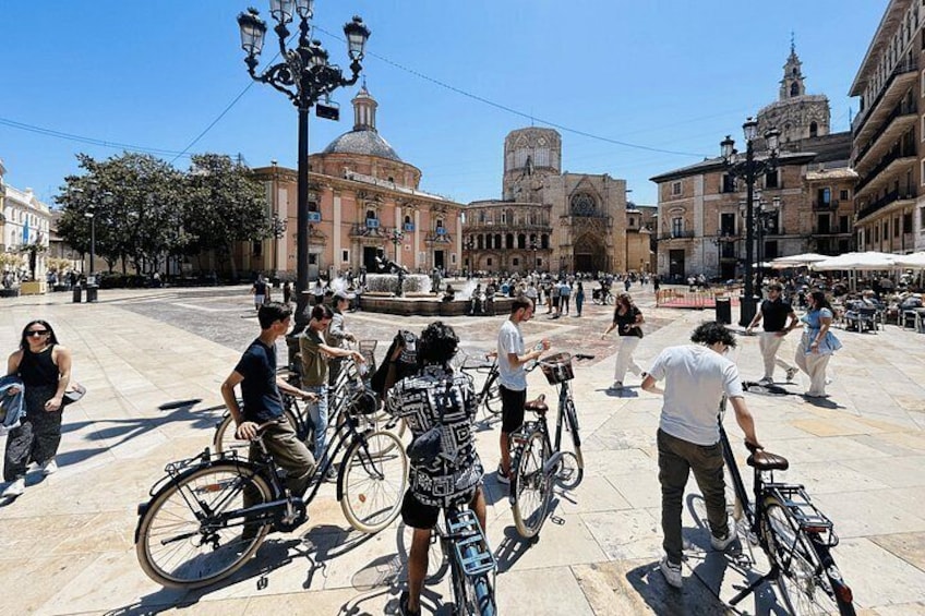 Una plaza pública con gente, bicicletas y edificios históricos. 5