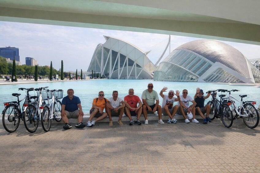 Un groupe de personnes posant devant une structure architecturale moderne agrémentée d’un élément aquatique. 3