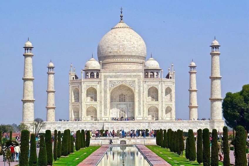 The Taj Mahal with four minarets, a large central dome, and a symmetrical garden with a reflecting pool. 5