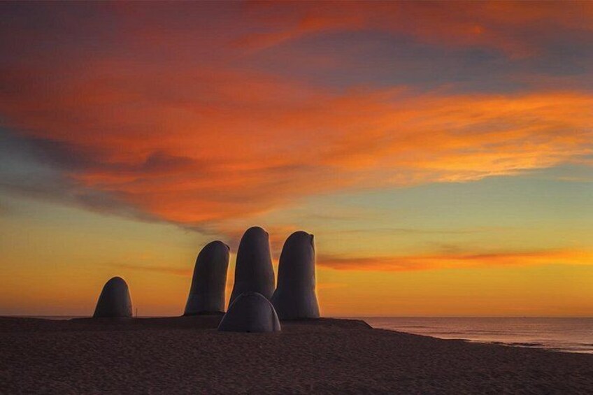 Una playa con grandes formaciones rocosas cónicas al atardecer. 1