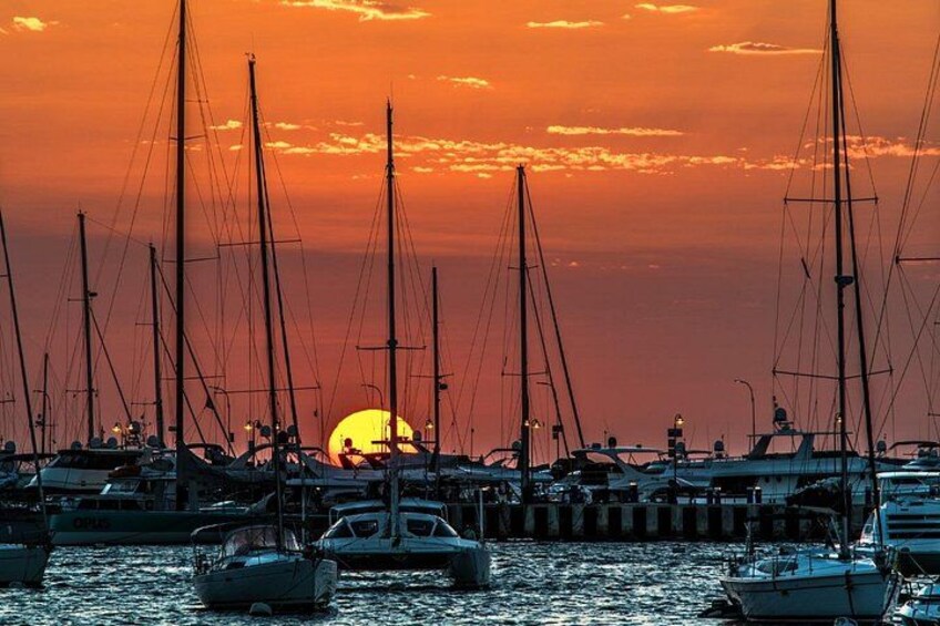 Un puerto deportivo con veleros amarrados al atardecer. 3