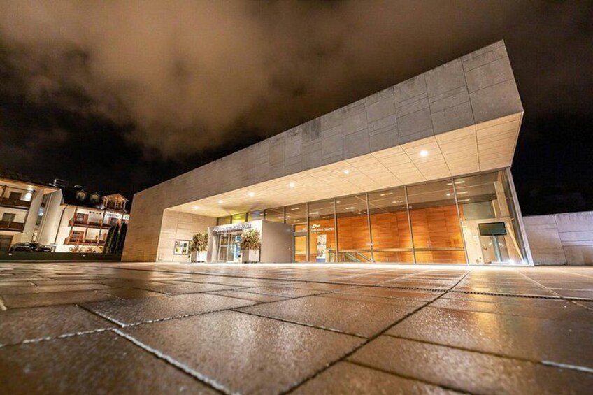 Un edificio moderno con facciata in vetro e marciapiede bagnato. 3