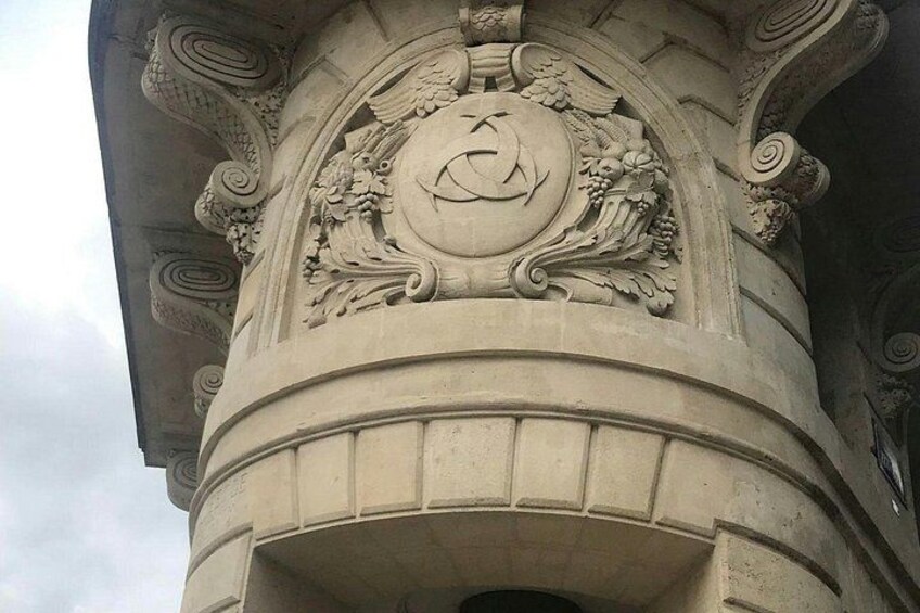 Een gedetailleerde stenen kolom met versierde gravures en een rond wapen. 4