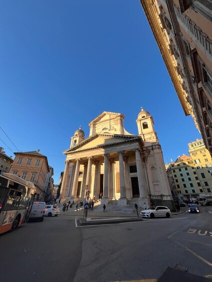 A classical building with columns and a dome, surrounded by urban streets and parked cars. 3