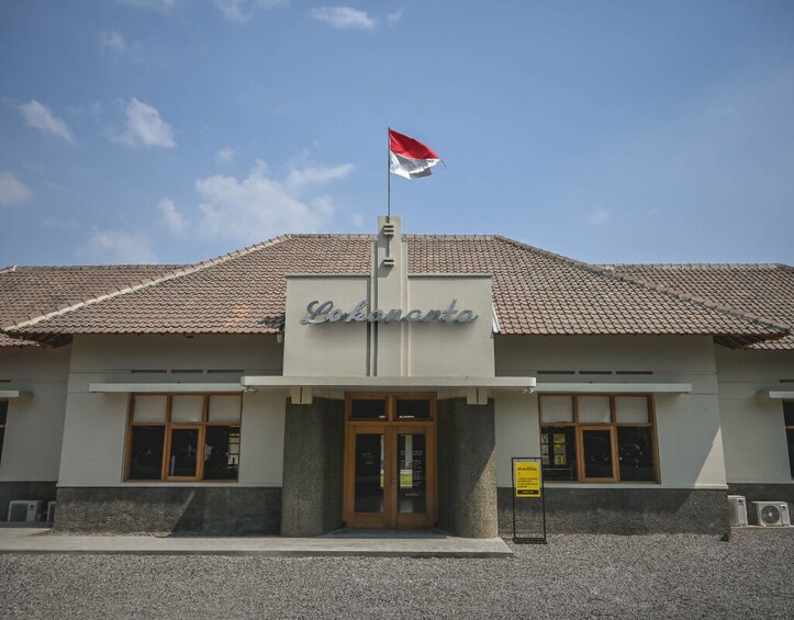 A building with a tiled roof and a flagpole with a flag. 1