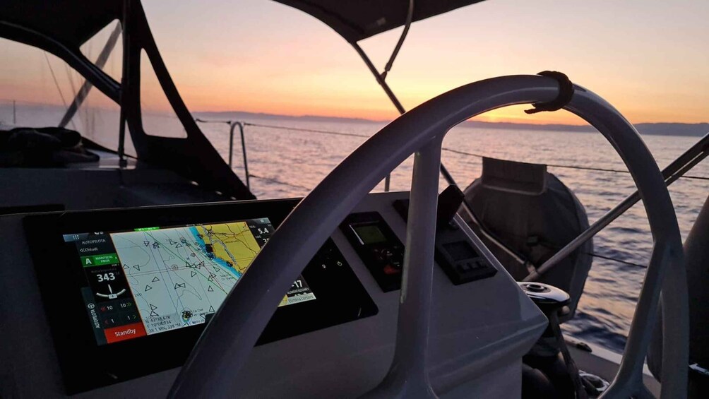 A boat's control panel with a GPS map and a steering wheel. 4