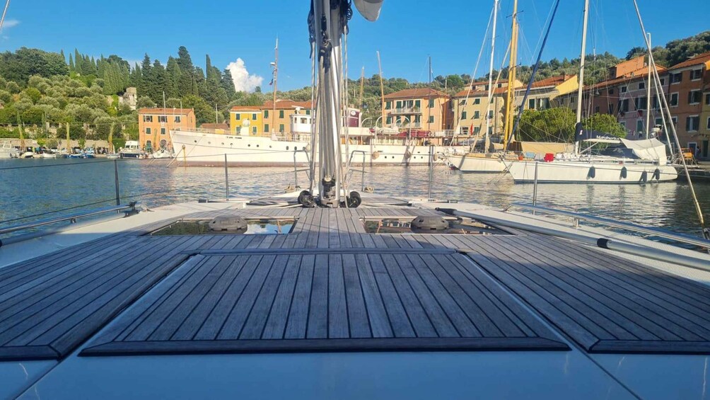 A wooden deck on a sailboat with a marina in the background. 5