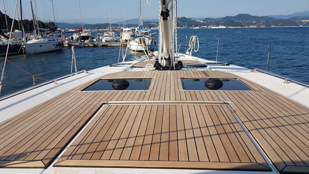 A wooden deck on a sailboat with two small windows and a rope tied to the mast. 3