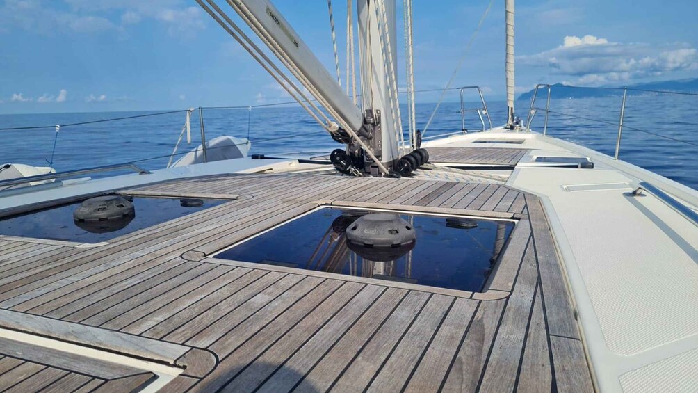 A wooden deck on a sailboat with a clear sky and calm sea. 2