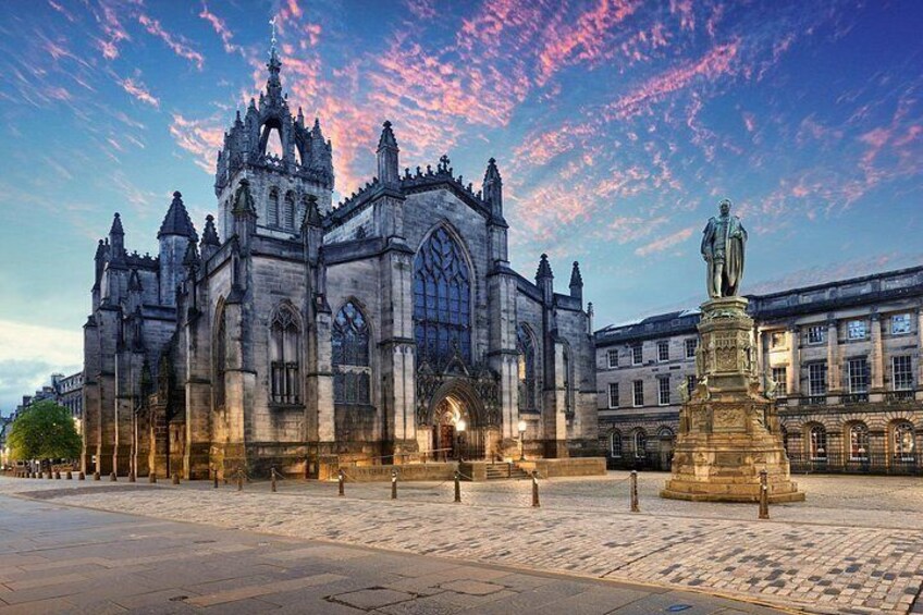 A historic cathedral with intricate architecture, a statue, and cobblestone pavement. 2