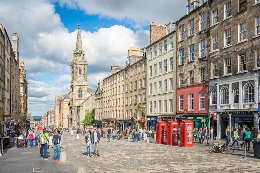 A historic city square with a prominent clock tower, cobblestone streets, and traditional buildings. 3