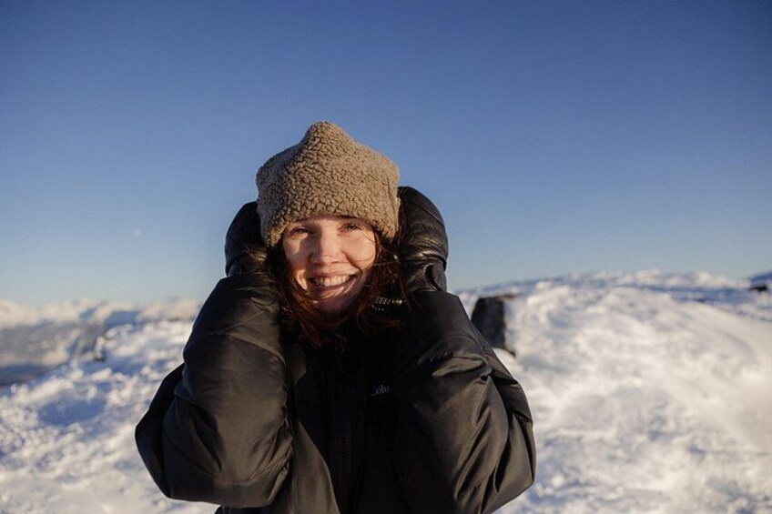 A person wearing a winter jacket and a hat, standing in a snowy landscape. 5