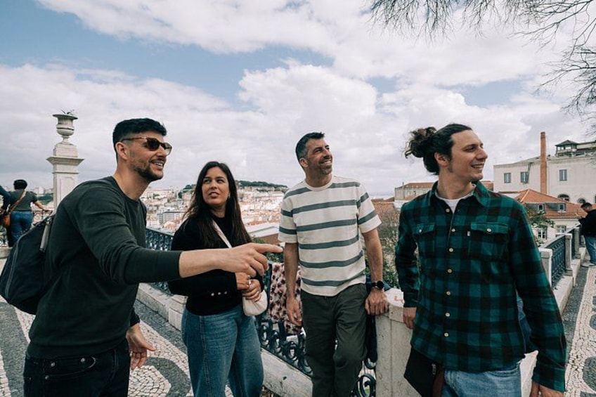 A group of people standing on a bridge with a cityscape in the background. 2