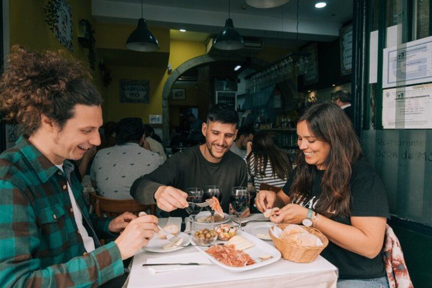 A group of people dining at a restaurant with a table set for a meal. 2