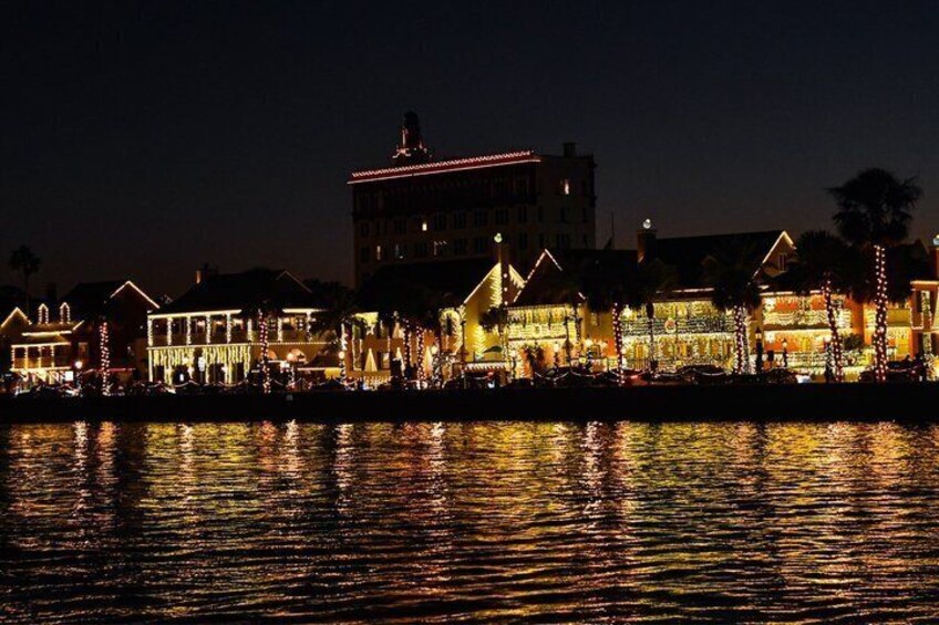 A waterfront with illuminated buildings reflecting on the water. 5