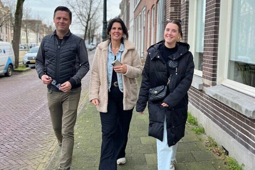 Three people walking on a sidewalk. 1