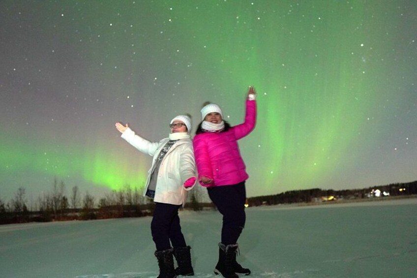 Two people ice skating under a night sky with the aurora borealis. 4