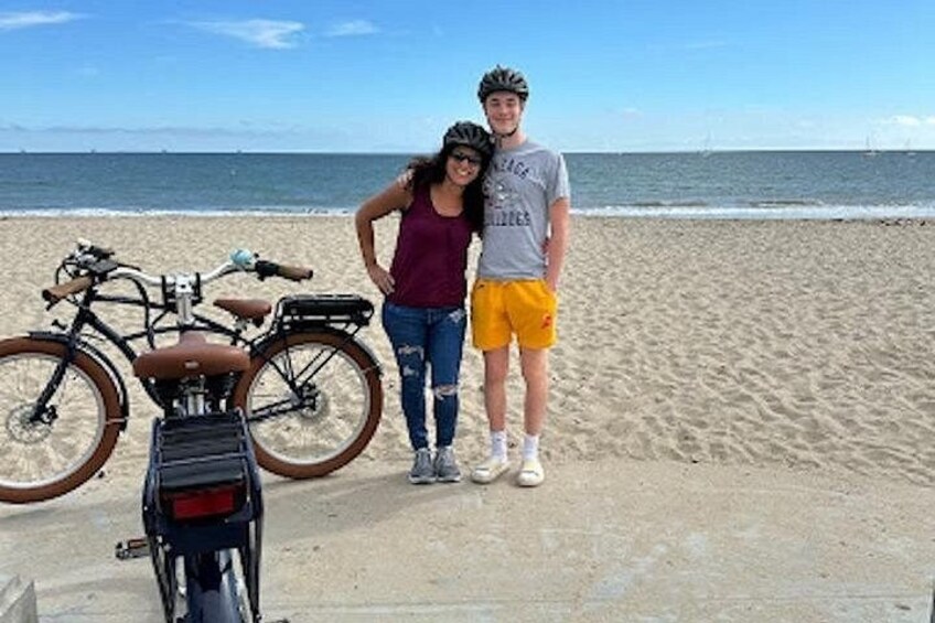 A beach with a bicycle and a person standing. 3