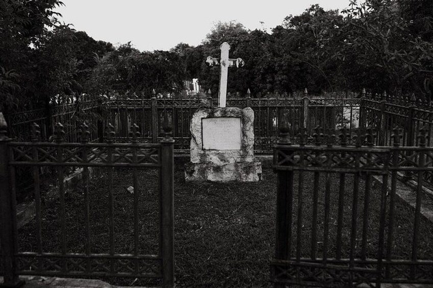 A cemetery with a central monument surrounded by a metal fence. 5