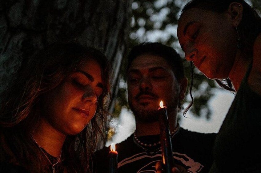 Three people gathered around a candle. 4