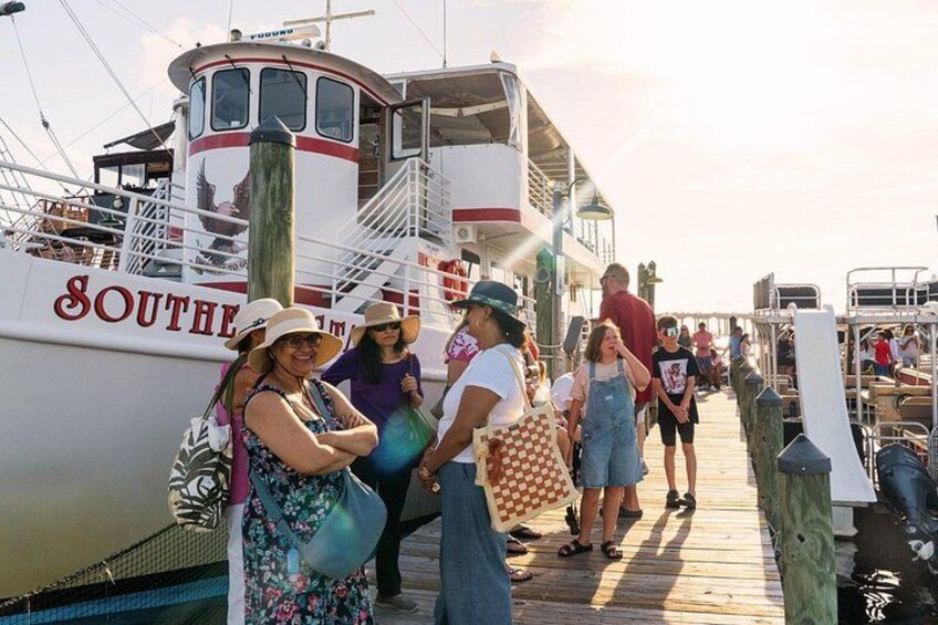 Un muelle con gente caminando, una embarcación con la inscripción 'SOUTHERN' y una pasarela de madera. 3