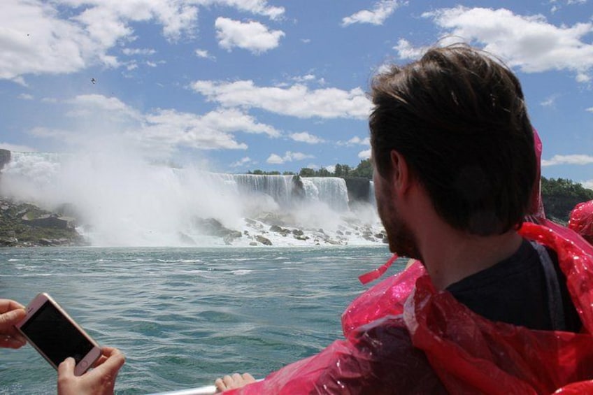 A person in a red raincoat looking at a waterfall. 4