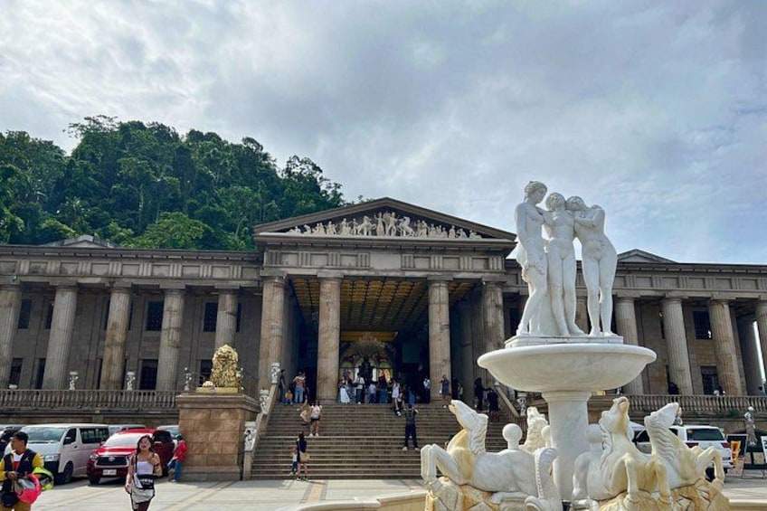 Ein klassizistisches Gebäude mit Säulen, einem Brunnen mit Skulptur und einer Treppe zum Eingang. 5