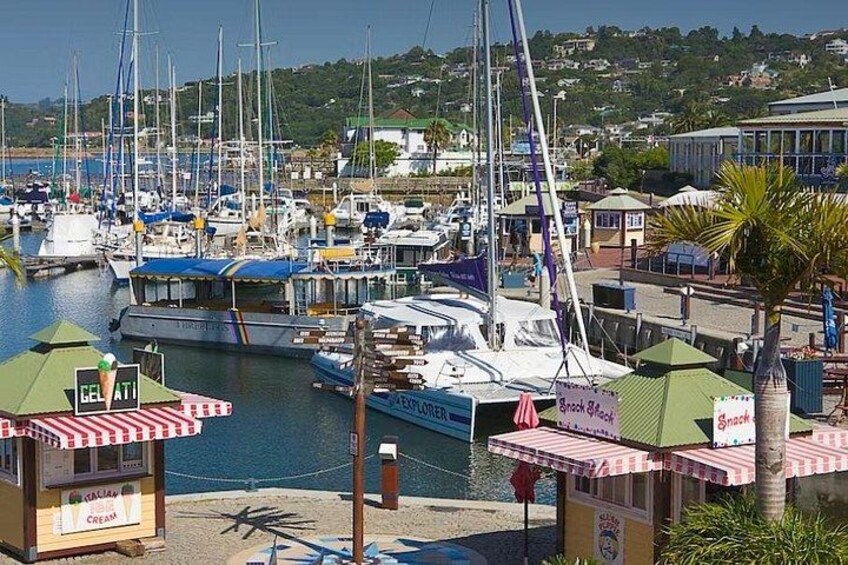A marina with boats docked, a gelato stand, and a snack bar. 2