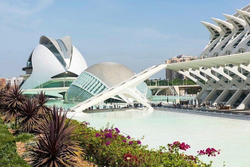 A modern architectural complex with unique structures, a body of water, and surrounding greenery. 4